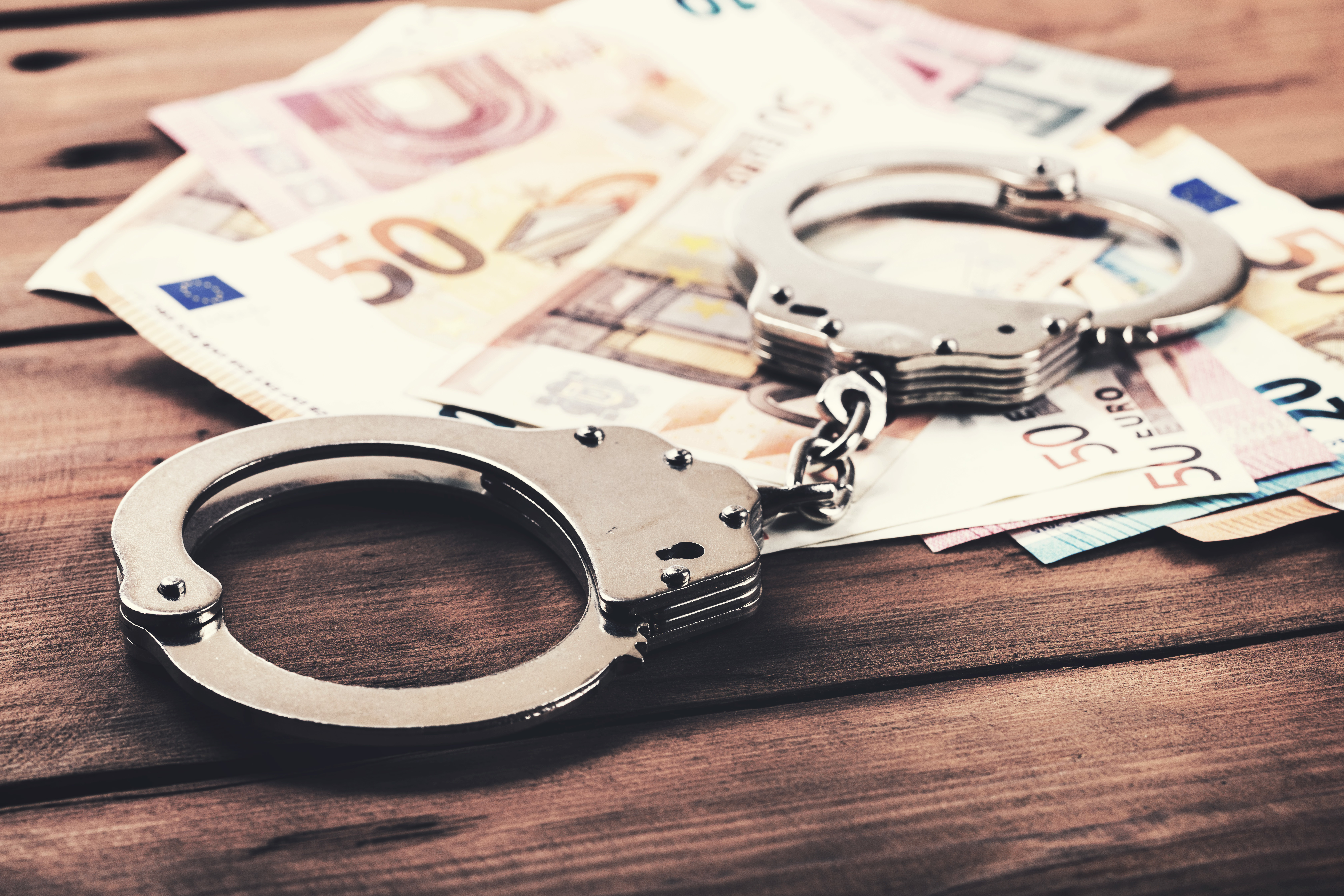 Banknotes with handcuff on table