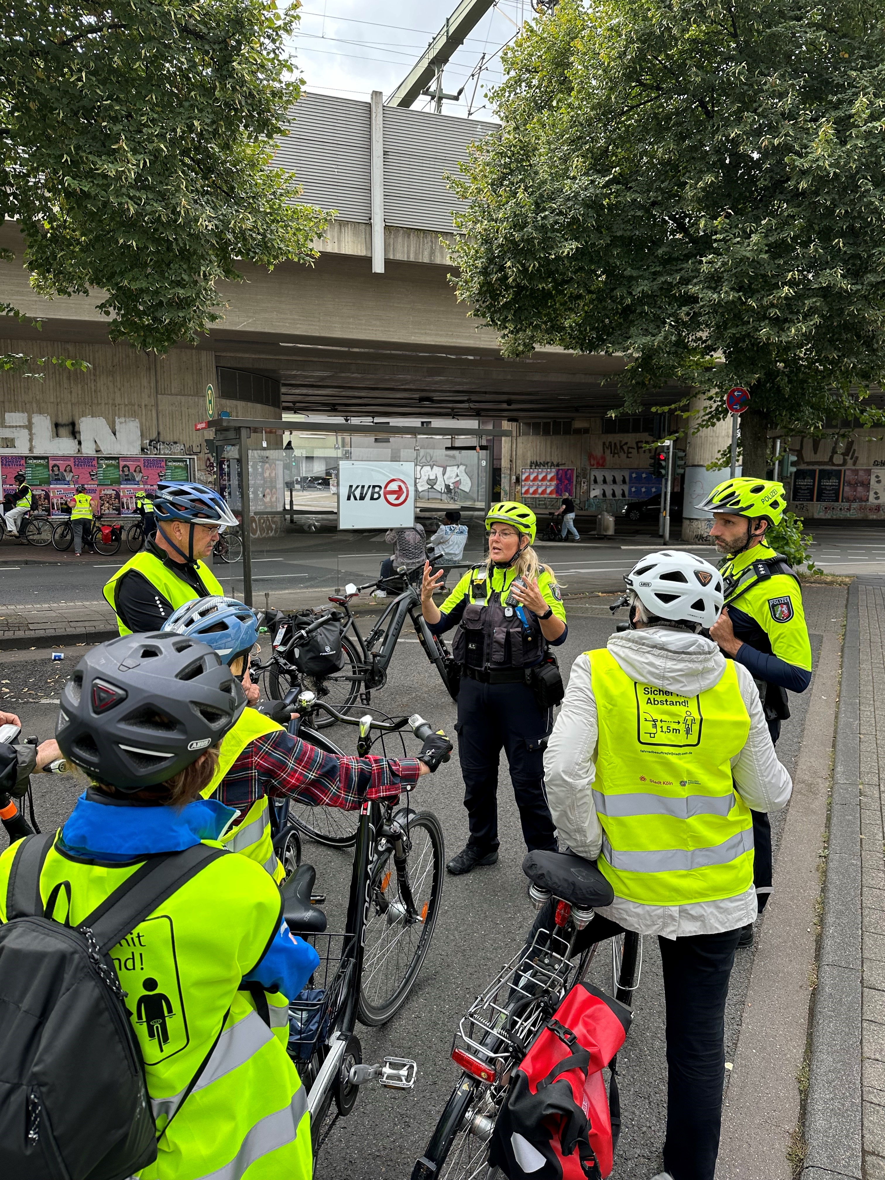 Polizisten erklärt Radfahrern etwas