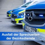 Drei Streifenwagen der Marke Mercedes stehen schräg im Hof. Unter den Fahrzeugen steht in einer blauen Banderole "Ausfall der Sprechstunden der Bezirksdienste"